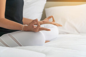 woman sitting in bed in the morning meditating